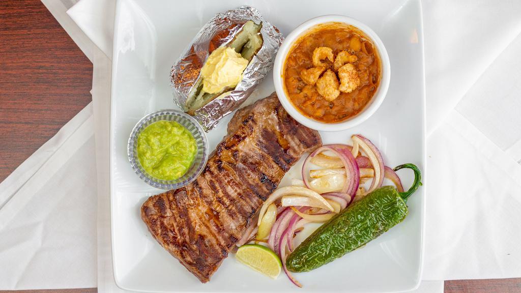 Arrachera · Tender skirt steak served with charro beans, grilled onions, chile toreado and choice of baked potato or fries