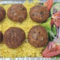 Falafel Over Rice · Falafel over rice served with salad and sauces.