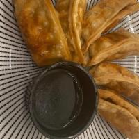 Potstickers (6 Pieces) · Six fried pork dumplings filled with meat, vegetables, and spices. Served with house made gy...