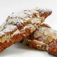 Almond Croissant · Flaky golden croissants are filled and topped with almond cream and sliced almonds.  Made fr...