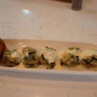 Stuffed Mushrooms · Spinach, bread crumbs, and cheeses in mushroom caps drizzled with parmesan cream sauce.