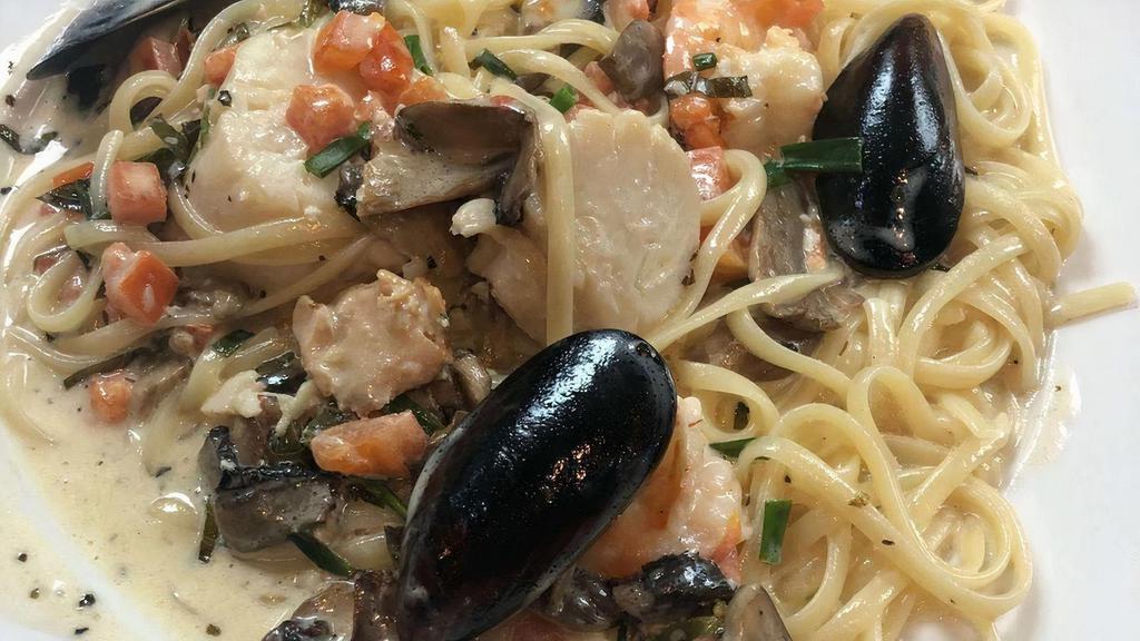 Di Mare · Shrimp, scallops, mussels, mushrooms, chices, and tomatoes in a white wine basil butter sauce atop linguini pasta.