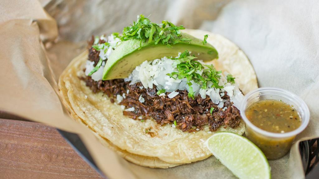 Democrat · Shredded beef barbacoa topped with fresh avocado, cotija cheese, cilantro, onions & a wedge of lime.  Served with TOMATILLO SAUCE on a fresh corn tortilla. Dairy, Avocado.