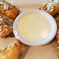 Taquitos · Crispy flour tortillas with choice of chicken or steak topped with sour cream, queso fresco ...