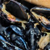 Traditional Mussels · One pound of Chilean mussels cooked in white wine garlic butter sauce with tomatoes and arti...