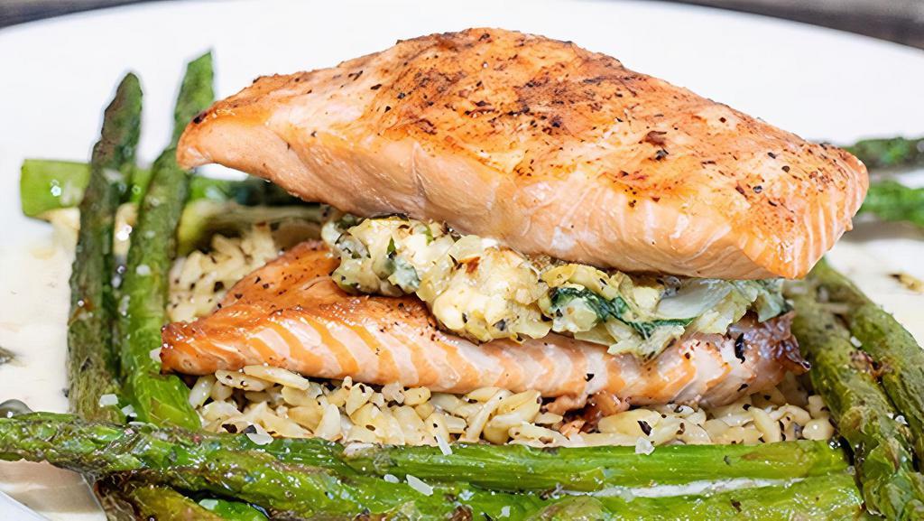 Crab & Artichoke Stuffed Salmon · Grilled Atlantic salmon filled with our homemade stuffing of crab, artichoke hearts, fresh spinach, and feta cheese. Served with sautéed asparagus and herbed orzo pasta with basil lemon butter.