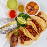 Tacos Al Pastor · Taco includes an order of 4 tacos, green onions, a jalapeño stuffed with cheese and wrapped ...