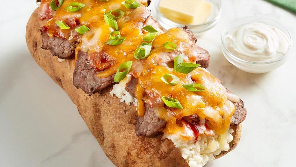 Loaded Steak Spud · Seared sirloin steak, applewood smoked bacon, cheddar jack cheese, and green onion in a giant spud