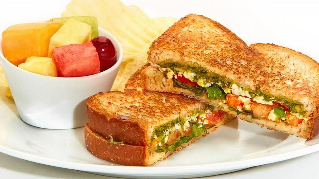 Tomato Basil Sandwich · Feta, tomatoes, basil and basil-pesto grilled on wheat bread. Served with chips. Vegetarian.
