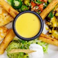 Texican Sampler · A taste of tex-mex! Queso clásico, beef fajita nachos, chicken fajita quesadillas, and flaut...