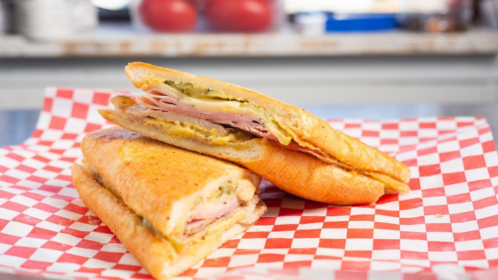 Cubano · Spice rubbed braised pork and ham topped with Swiss, pickles and mustard sauce on griddled French bread.