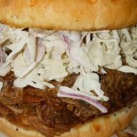 The Colossus Pulled Pork Sandwich · Tender braised pork shoulder with fresh jalapeño slaw and spicy bbq sauce on grilled onion r...