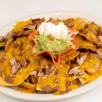 Fajita Nachos · A platter of chips topped with refried beans, beef and/or chicken fajita meat and melted che...