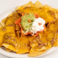 Bean & Cheese Nachos · A platter of chips topped with refried beans and melted cheddar cheese. Now served with Guac...
