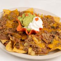 Picadillo Nachos · A platter of chips topped with refried beans, picadillo meat and melted cheddar cheese. Serv...