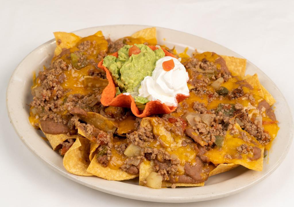 Picadillo Nachos · A platter of chips topped with refried beans, picadillo meat and melted cheddar cheese. Served with guacamole and sour cream.