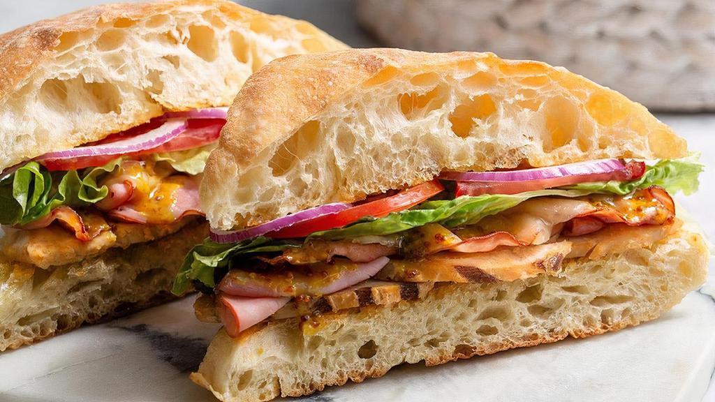 Famous | Chicken, Cheese, & Ham · Grilled chicken breast, ham, mayonnaise, honey mustard, Swiss cheese, lettuce, tomatoes, red onions, salt & pepper. Served on Ciabatta.
