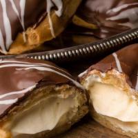Chocolate Eclair · Egg flour shell with a vanilla custard filling; dipped in imported Swiss chocolate ganache.