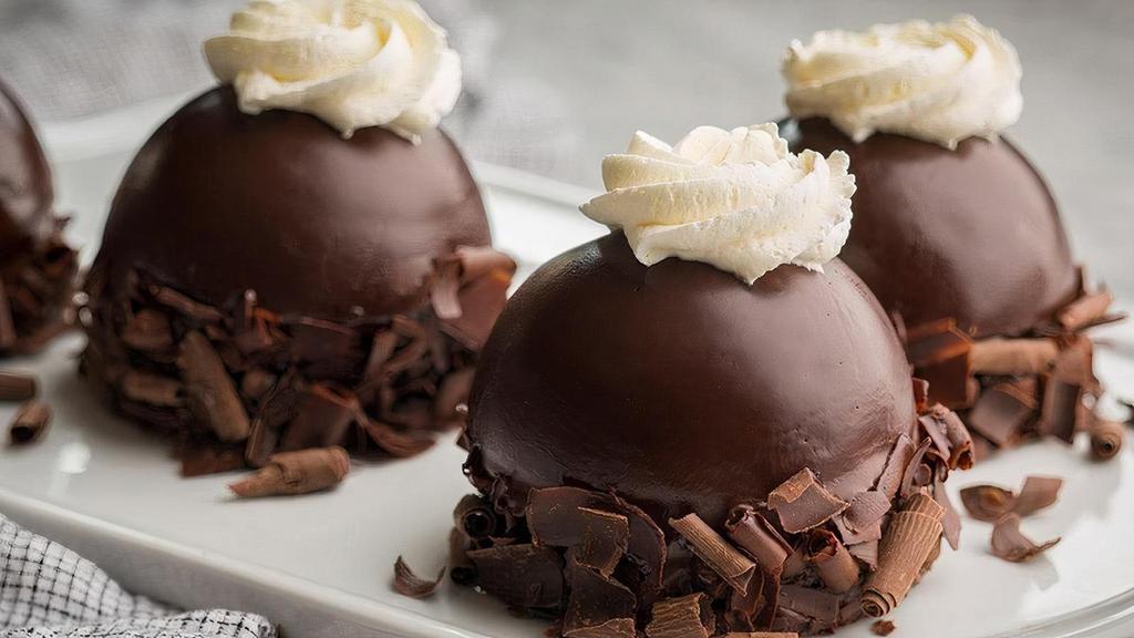 Chocolate Mousse Dome · Chocolate cake, with a mound of imported Swiss chocolate mousse, covered with imported chocolate ganache and topped with whipped topping.