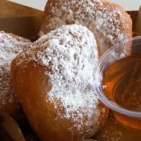 Beignets · Soft and fluffy squared shaped pastry. Lightly sprinkled with powdered sugar, served with ho...