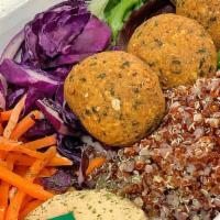 Falafel Bowl · Fried falafel, quinoa, hummus, spring mix, grated carrots, purple cabbage served in a bowl.