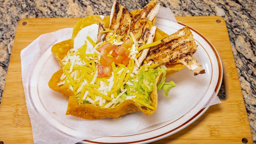 Chicken Taco Salad · chicken served with guacamole, sour cream, lettuce, tomato  and cheese.