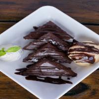 Chocolate Chip Brownie Sundae · Warm brownie wedges, homemade vanilla ice cream, chocolate sauce + whipped cream