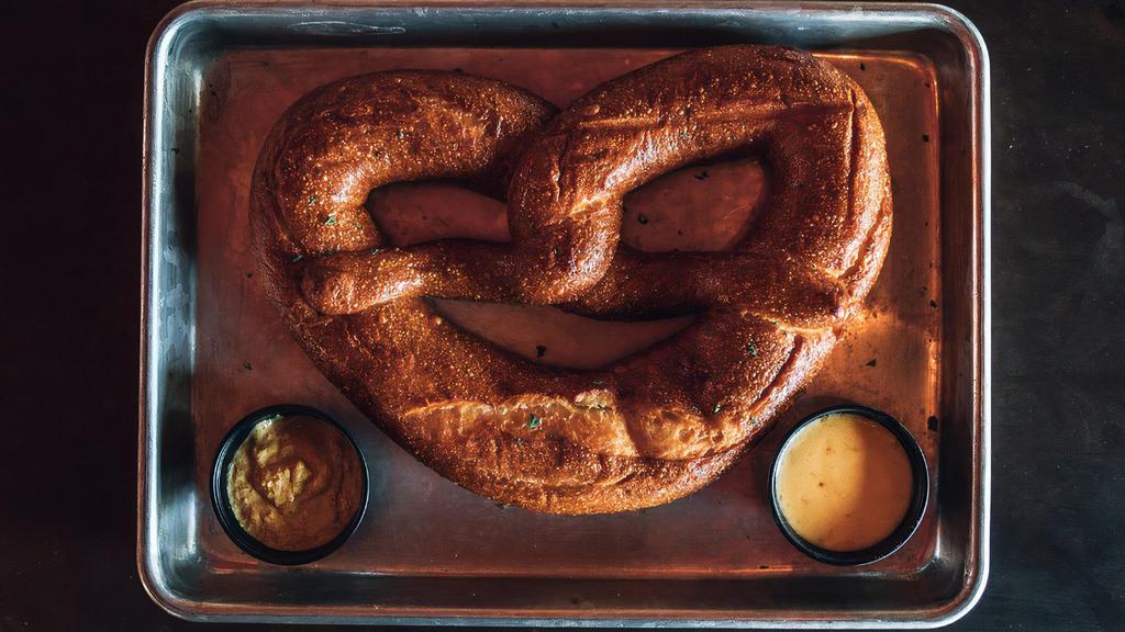 Pretzel · Locally baked pretzel from 'Cake & Bacon'.  Served with whole grain mustard and Cheddar beer sauce.