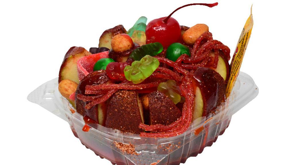 Manzana Preparada · Apple covered in chamoy paste and chile Miguelito with liquid chamoy, salsagheti, assorted gummies, peanuts and lime juice.