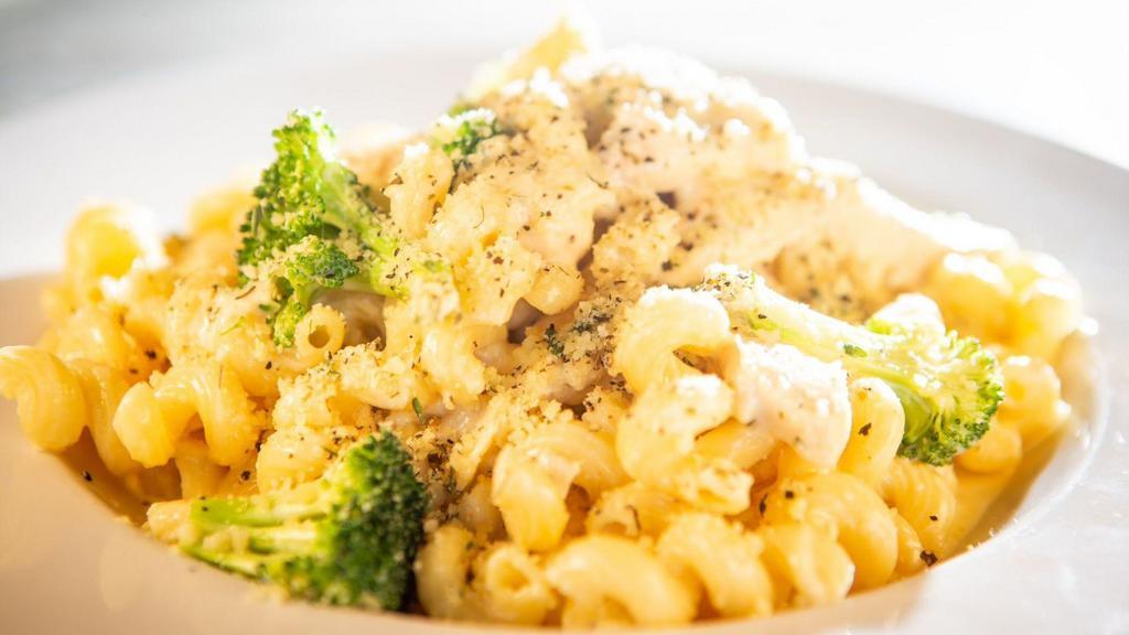 Middle Village Alfredo · Cavatappi pasta served with creamy Alfredo sauce, fresh roasted chicken and broccoli florets, garnished with parsley and Parmesan.