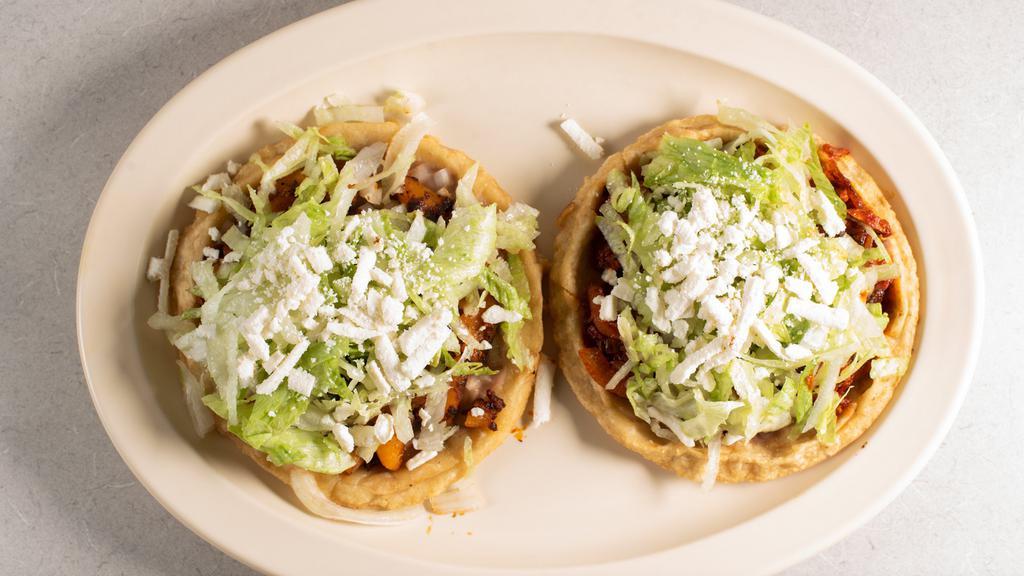 Sopes Mexicanos (2) · Two homemade tortillas with refried beans, your choice of meat, lettuce, onions and queso fresco.