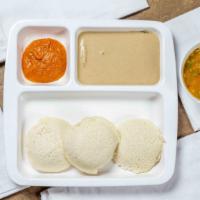Idly · Two rice cakes served with sambar and chutney.