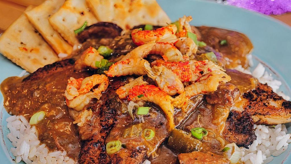 Catfish Tout · Two blackened fillets on a bed of white rice, smothered with a mixture of gumbo, etouffee and crawfish.