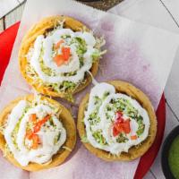 Sopes · Three deep fried corn sopes topped with beans, meat of your choice, lettuce, Mexican sour cr...