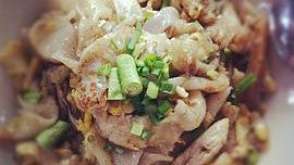 Kway Tiew Kua · Pan-fried flat rice noodles with egg, bean sprouts in light brown sauce. Garnished with scal...