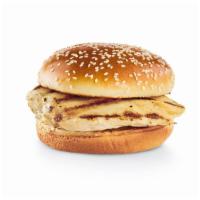 Simply Grilled Chicken Burger · Grilled chicken breast, pickles, lettuce, tomatoes and red onions on the side on a sesame bun.