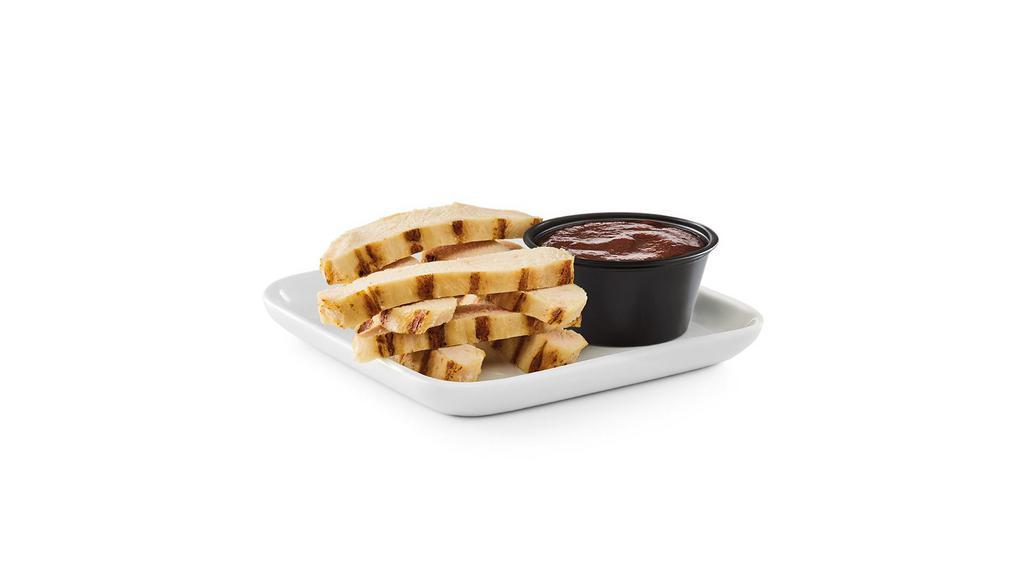 Kids Grilled Chicken Strips · Bite-sized strips of grilled chicken breast with a side of dipping sauce.