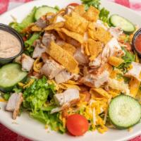Southwest Salad · A heaping mound of Fritos, red beans and grilled chicken breast, served on crispy salad gree...