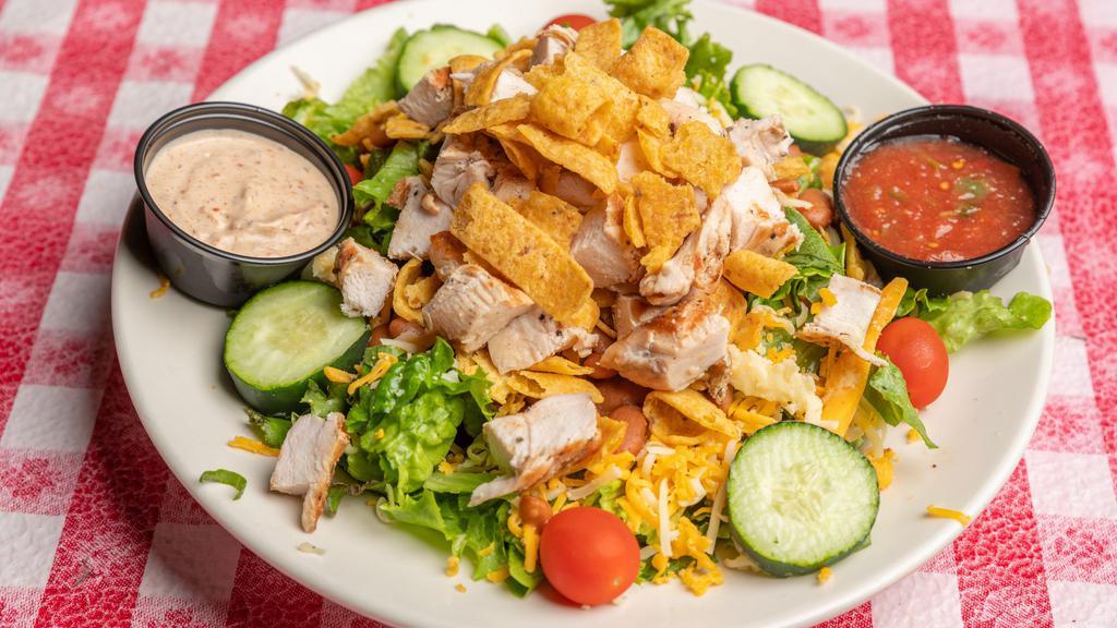 Southwest Salad · A heaping mound of Fritos, red beans and grilled chicken breast, served on crispy salad greens with Swiss and cheddar cheese, tomatoes, cucumbers and homemade salsa (on the side).