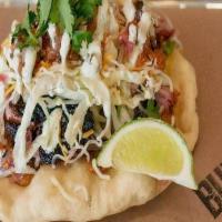 Navajo Fry Bread Taco · Traditional Navajo Fry Bread, with Pinto Bean Smash,  Choice of Meat, Lettuce Shredded, Ched...