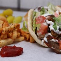 Gyro · Thin cuts of Gyro, tomato, lettuce and onion marinated in sumac wrapped in pita bread with y...
