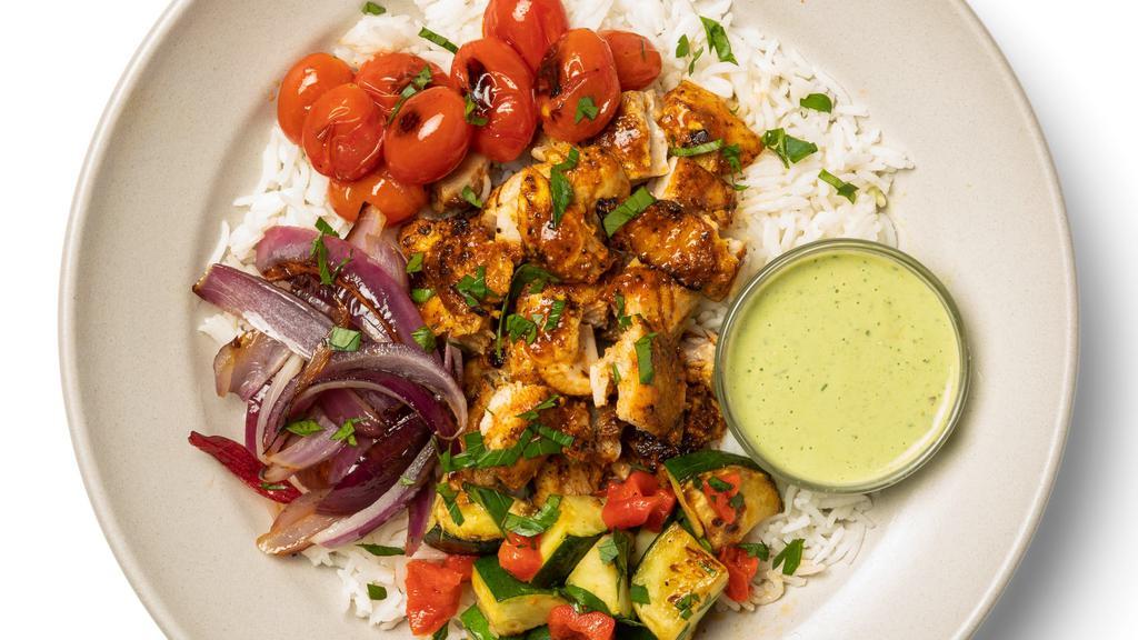 Shawarma Chicken Bowl With Lemon-Tahini Sauce · Some say variety is the spice of life, and variety is what you get in this Shawarma Chicken Bowl! Shawarma-spiced chicken breast is served alongside roasted onions, tomatoes, zucchini, all over a bed of basmati rice, served with a lemon tahini sauce.