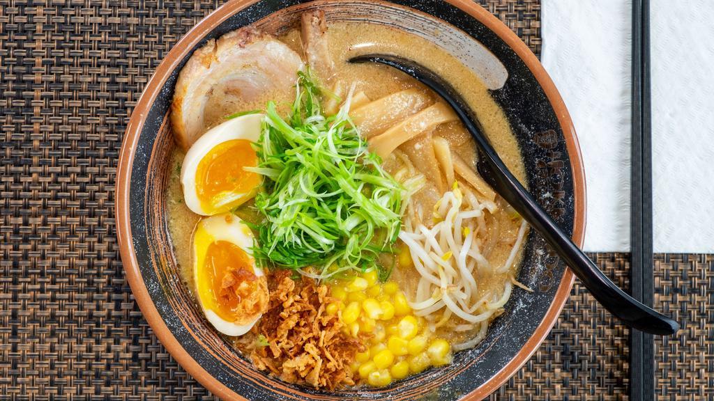 Miso Ramen · A rich pork and chicken broth with a light garlic and soy bean base. Toppings: A slice of grilled pork chashu, fried onions, sweet corn, bamboo shoots, bean sprouts, and scallions.