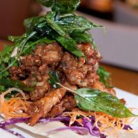 Thai Herbal Chicken · Crispy chicken infused with Thai herbs and seasonings. Topped with crispy basil leaves
