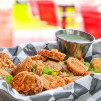 Boudin Chips · Bold boudin slices dusted in flour, fried, and finished with Cajun spices. Served with butte...