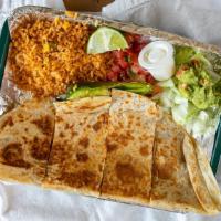 Quesadilla · large flour tortilla filled with meat and melty cheese.  Served with rice, grilled onion, gr...