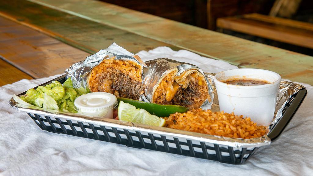 Burrito · warm flour tortilla filled with meat, rice, beans and cheese. Served with rice, beans, grilled onion, grilled jalapeño, lime, lettuce, pico, guac, sour cream...over a pound of food!