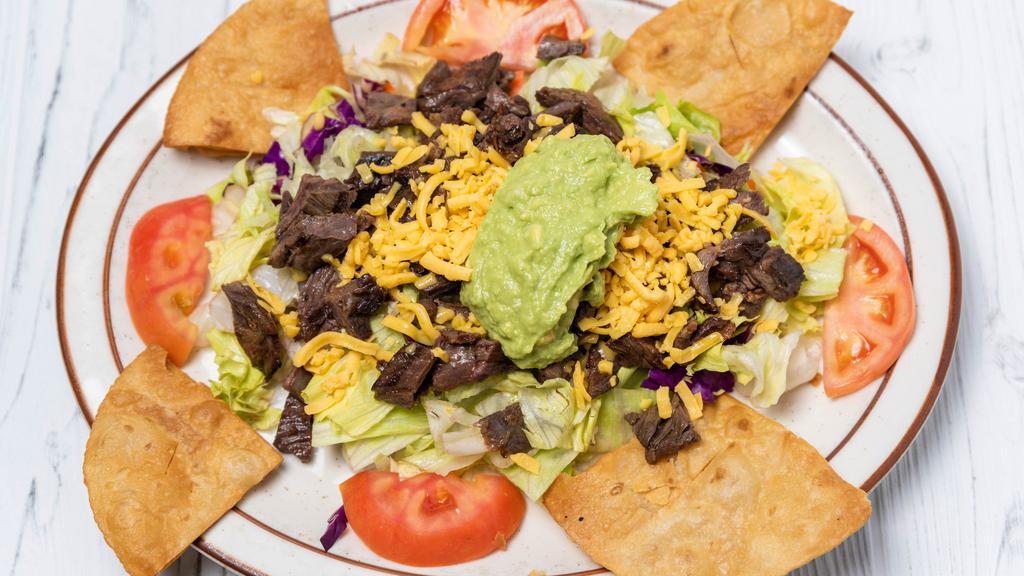 Fajita Taco Salad · Tender juicy chunks of beef or chicken fajita meat, flour tortilla chips, lettuce, tomato, grated cheese and guacamole.