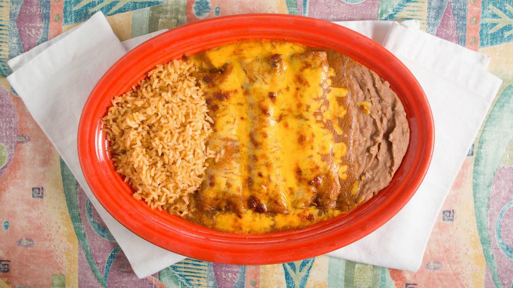Beef Enchiladas · Three ground beef enchiladas covered with gravy and cheese served with rice and beans.