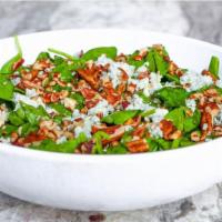 Spinach Salad · Fresh baby spinach topped with red onion, bacon, gorgonzola, and pecan bits tossed in our st...